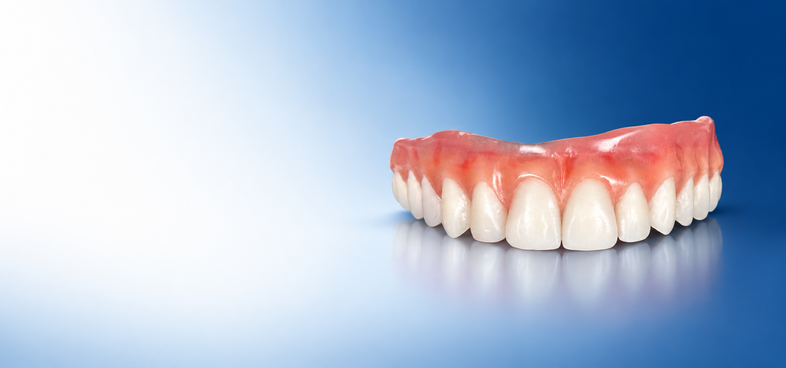 Prótese dentária sobre fundo azul da Sorrisus Joinville